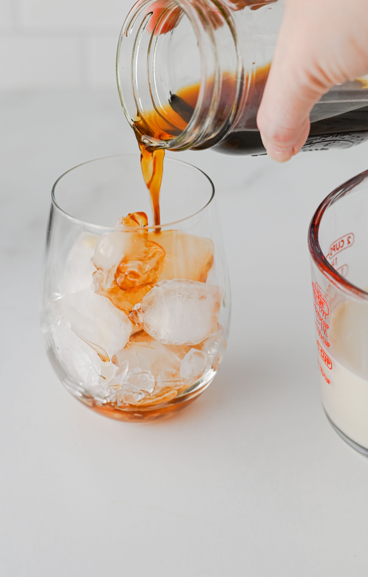 Chai concentrate being poured over ice in a glass