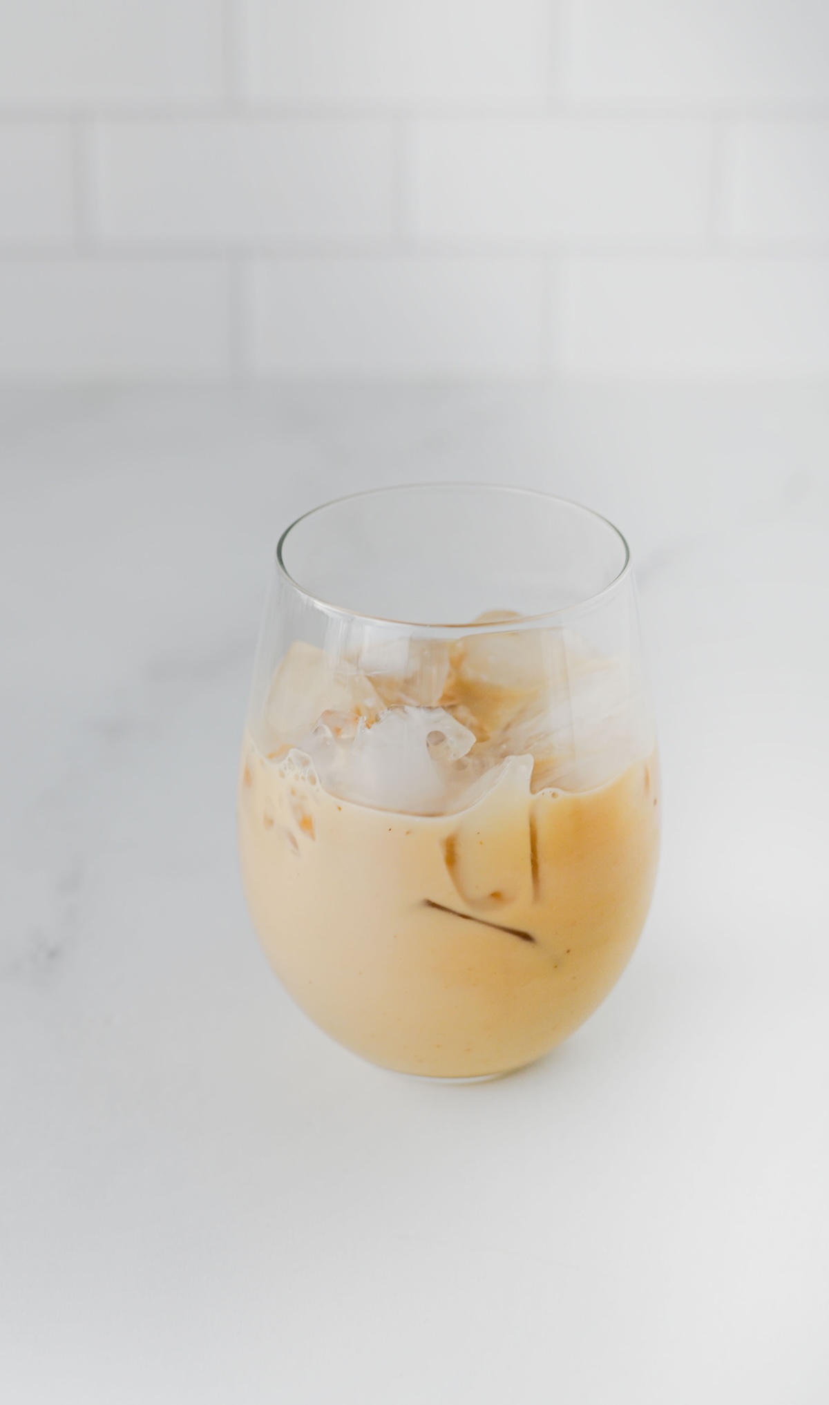 Glass of iced chai with oat milk before adding the gingerbread foam