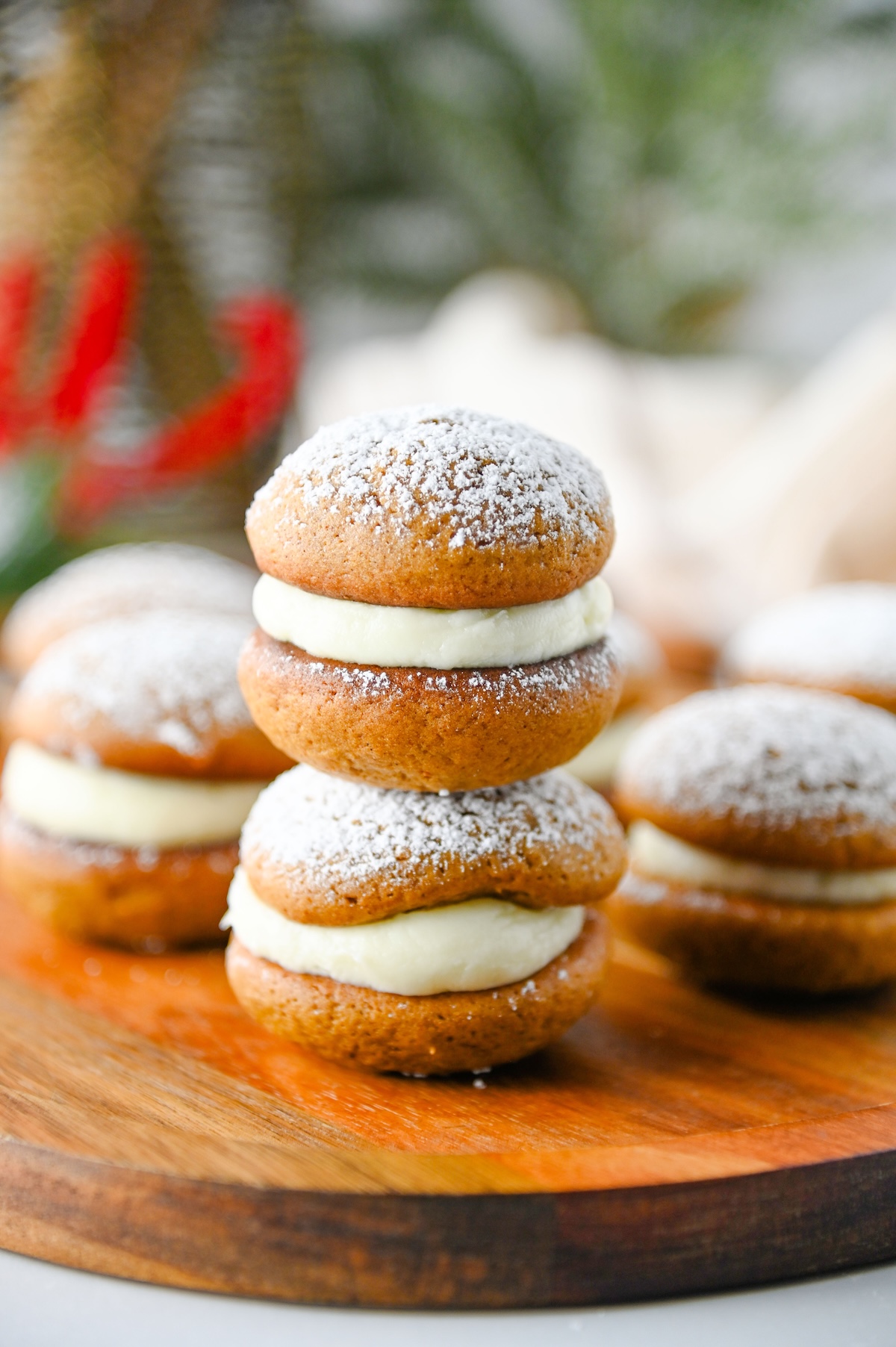 Two gingerbread whoopie pies stacked on top of each other, showing the cream cheese filling