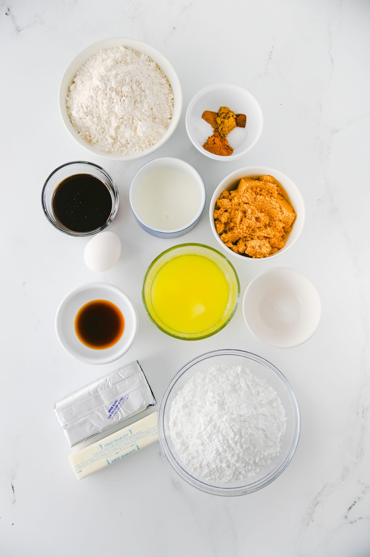 Ingredients for gingerbread whoopie pies, including flour, spices, molasses, brown sugar, egg, butter, cream cheese, and powdered sugar