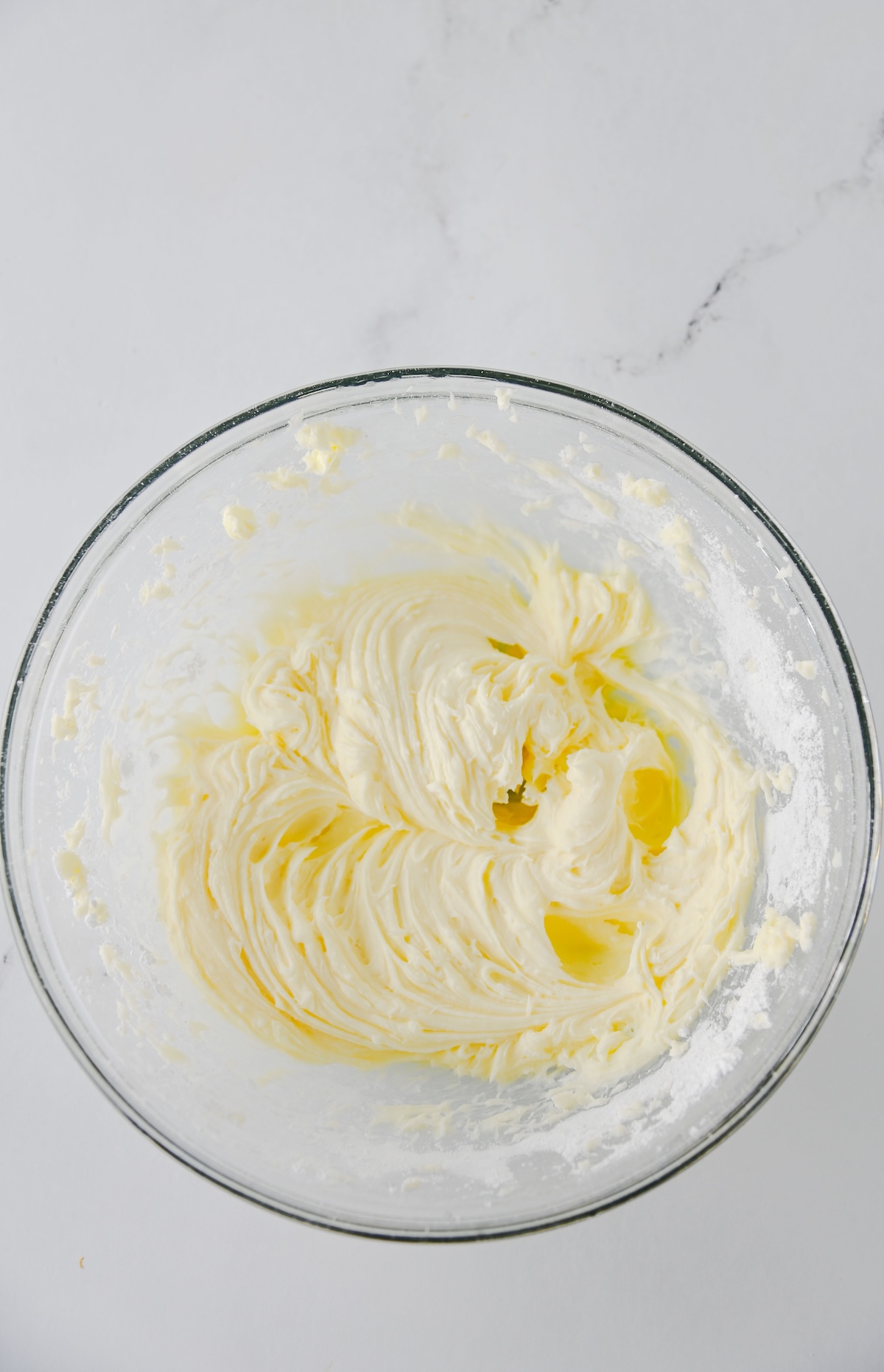 Whipped cream cheese filling in a glass mixing bowl