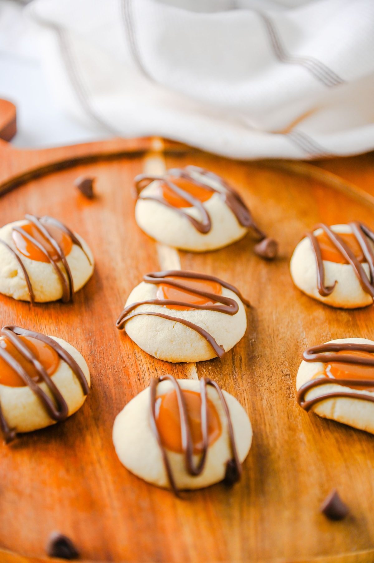 Close-up of Twix thumbprint cookies with gooey caramel centers and milk chocolate drizzle