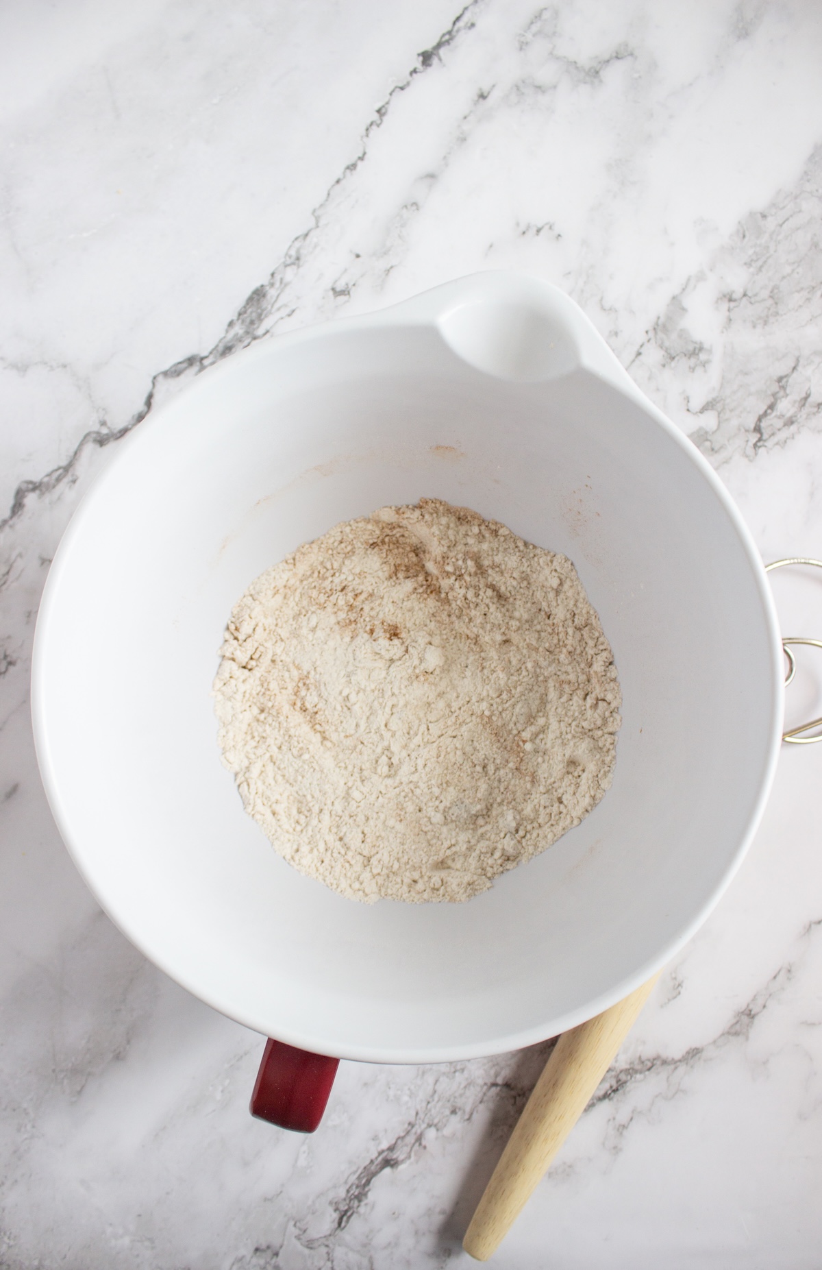 Whisked dry ingredients for apple cinnamon pancakes in a white mixing bowl