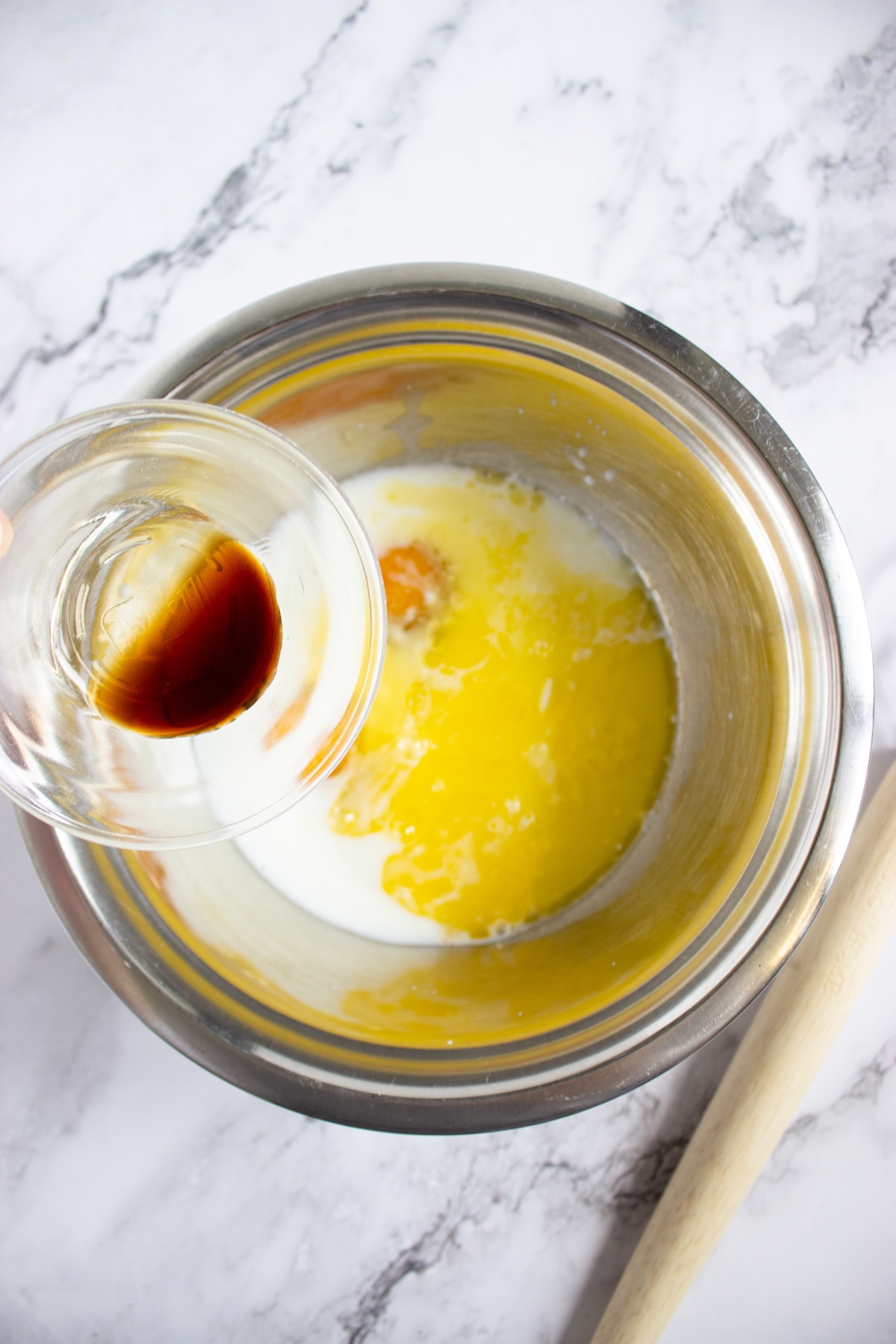Vanilla extract being added to the wet ingredients for pancake batter