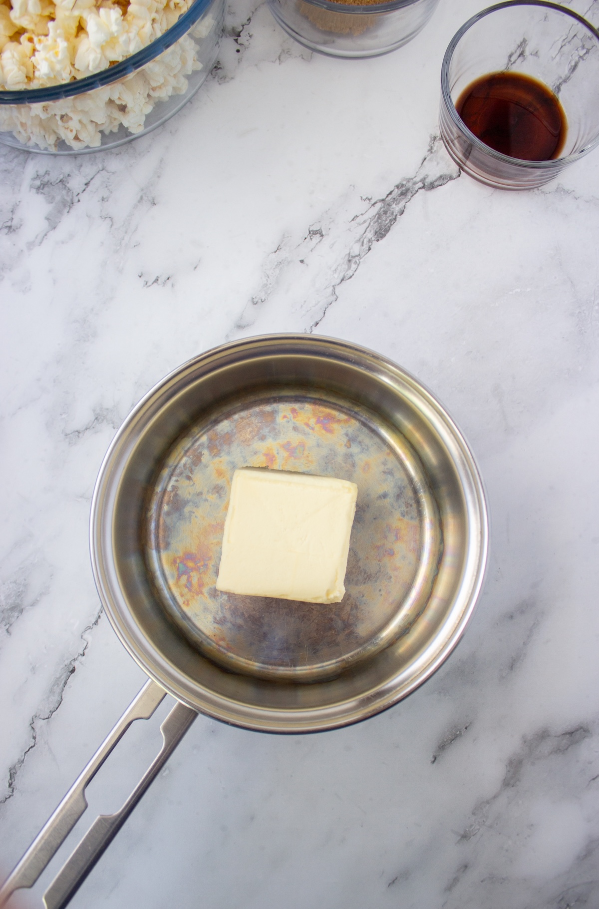 Stick of butter melting in a stainless steel saucepan