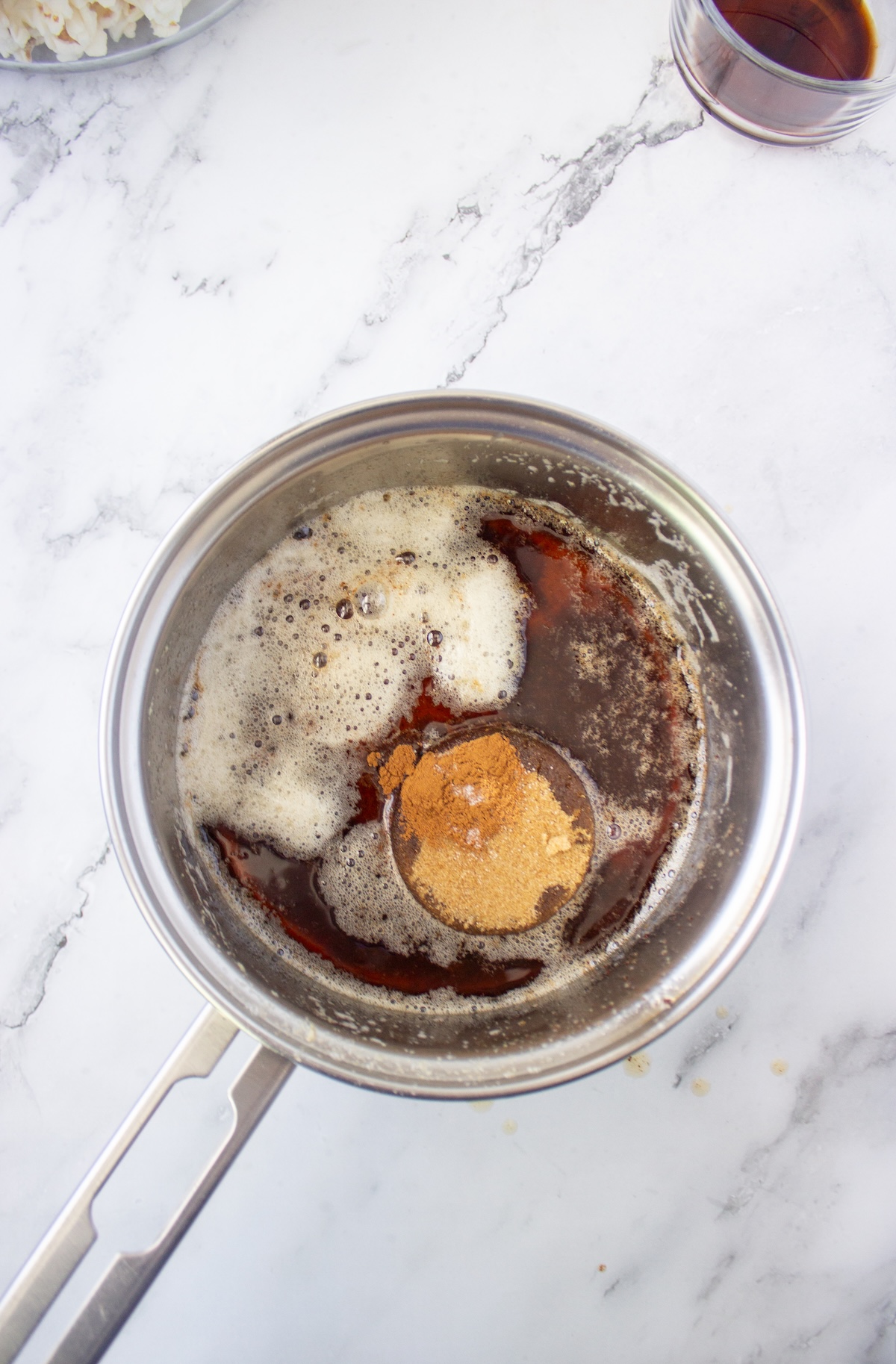Spices and brown sugar on top of the maple butter mixture before stirring