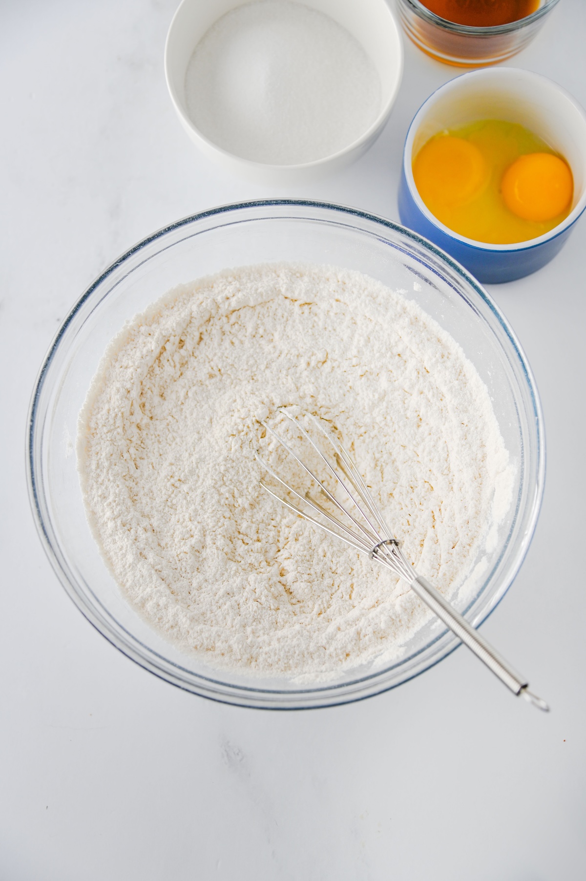 Flour whisked together in a large glass mixing bowl for Twix thumbprint cookies
