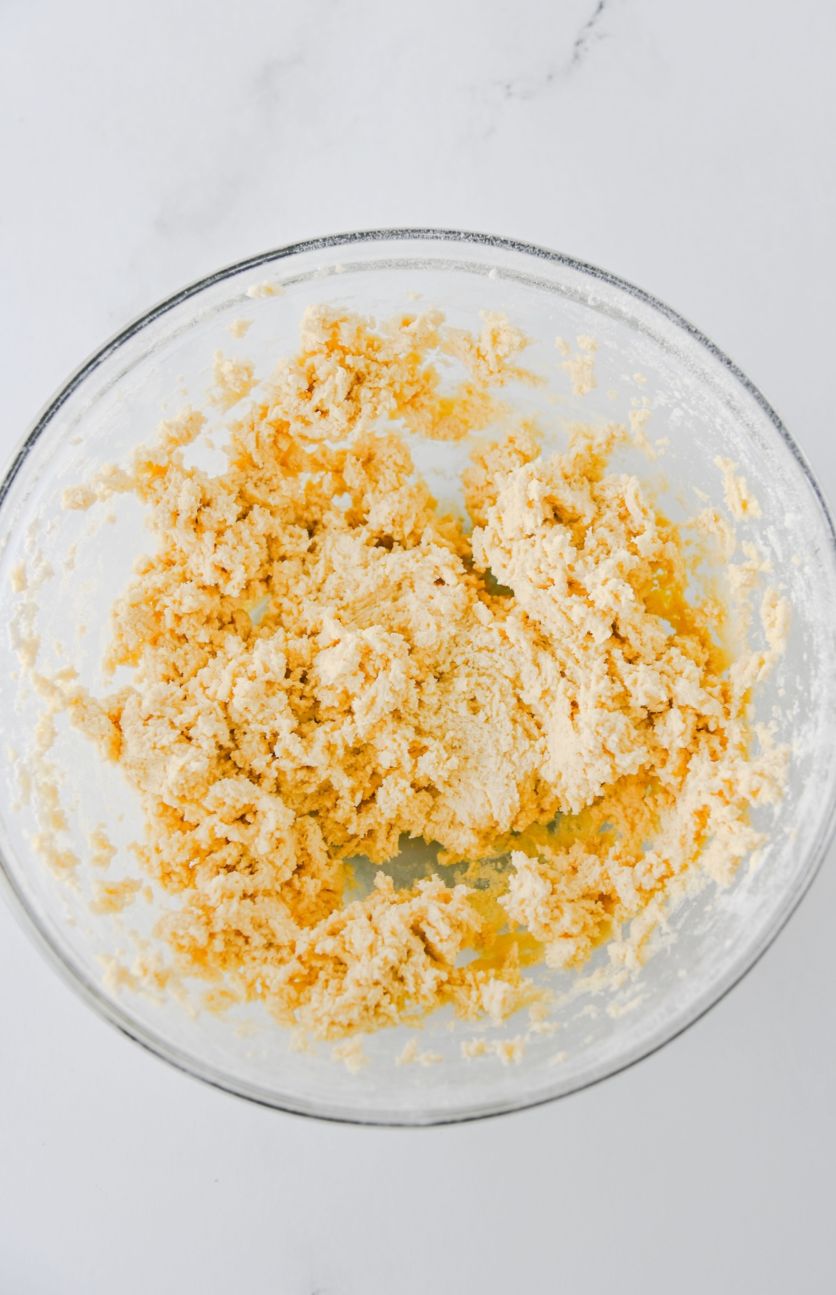 Crumbly Twix thumbprint cookie dough mixed in a glass bowl