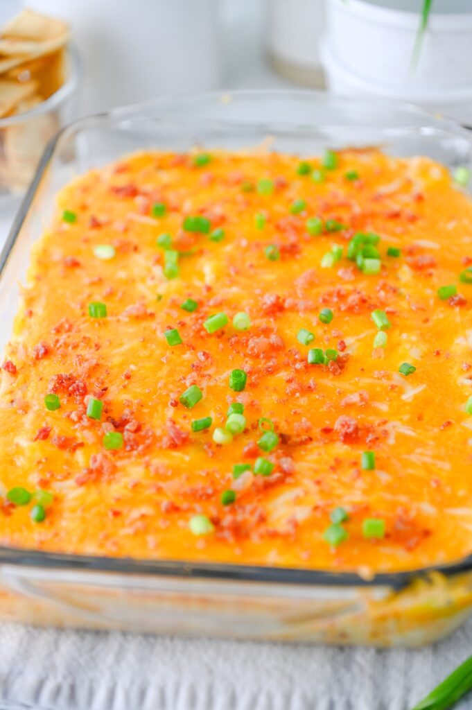 Crack chicken dip topped with melted cheddar, bacon, and sliced green onions