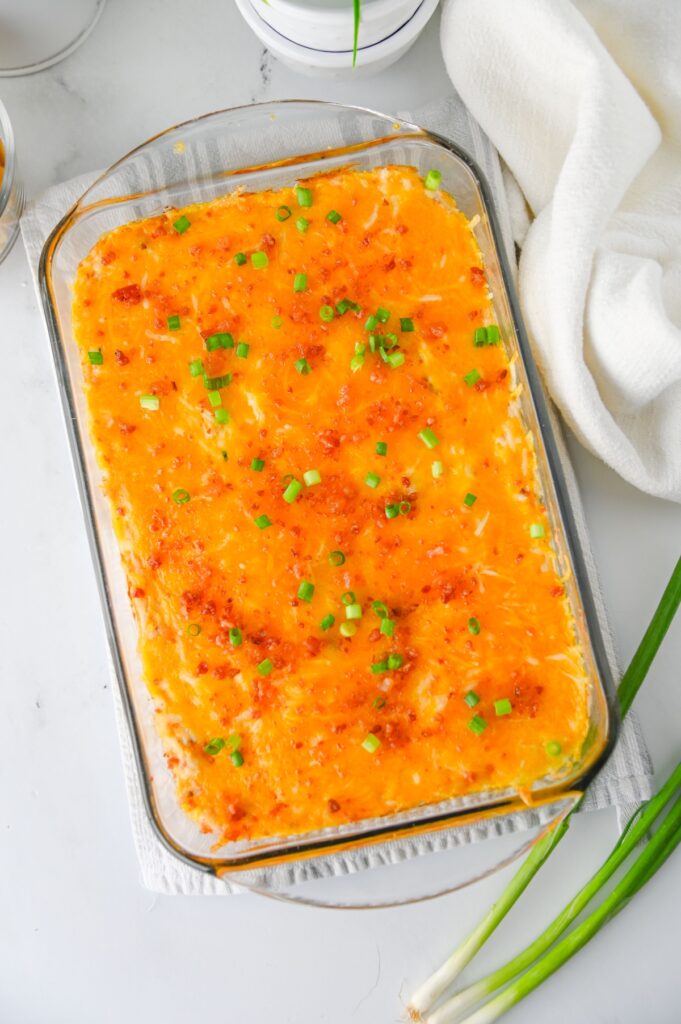 Overhead view of crack chicken dip in a glass baking dish with green onions