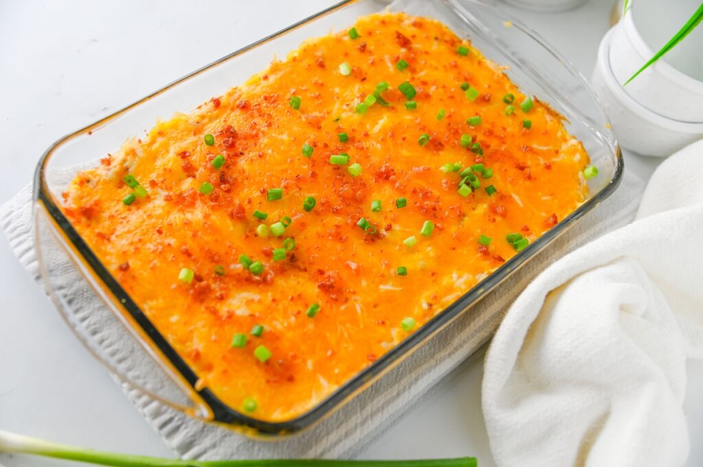 Baked crack chicken dip in a glass dish on a white linen towel