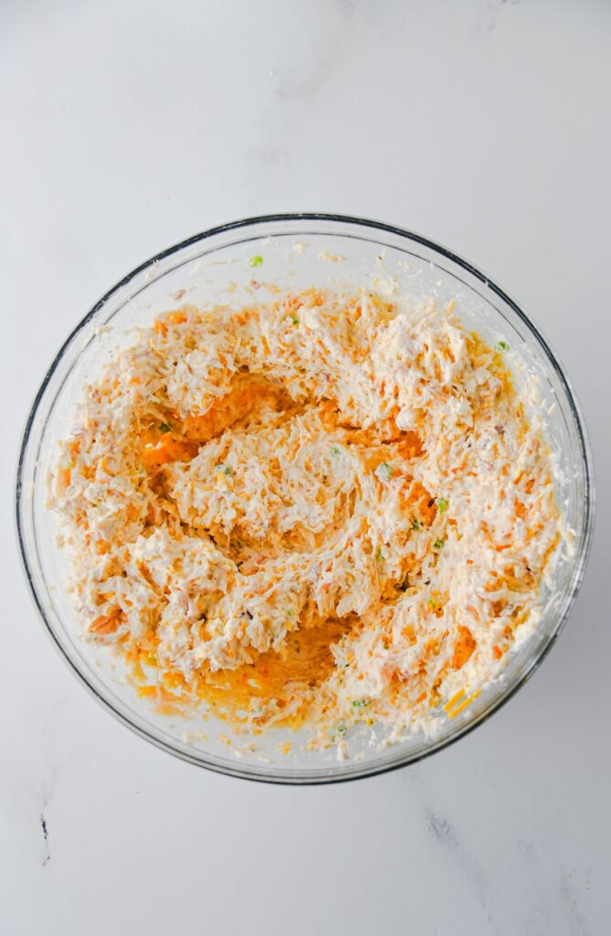 Crack chicken dip ingredients mixed together in a large glass bowl
